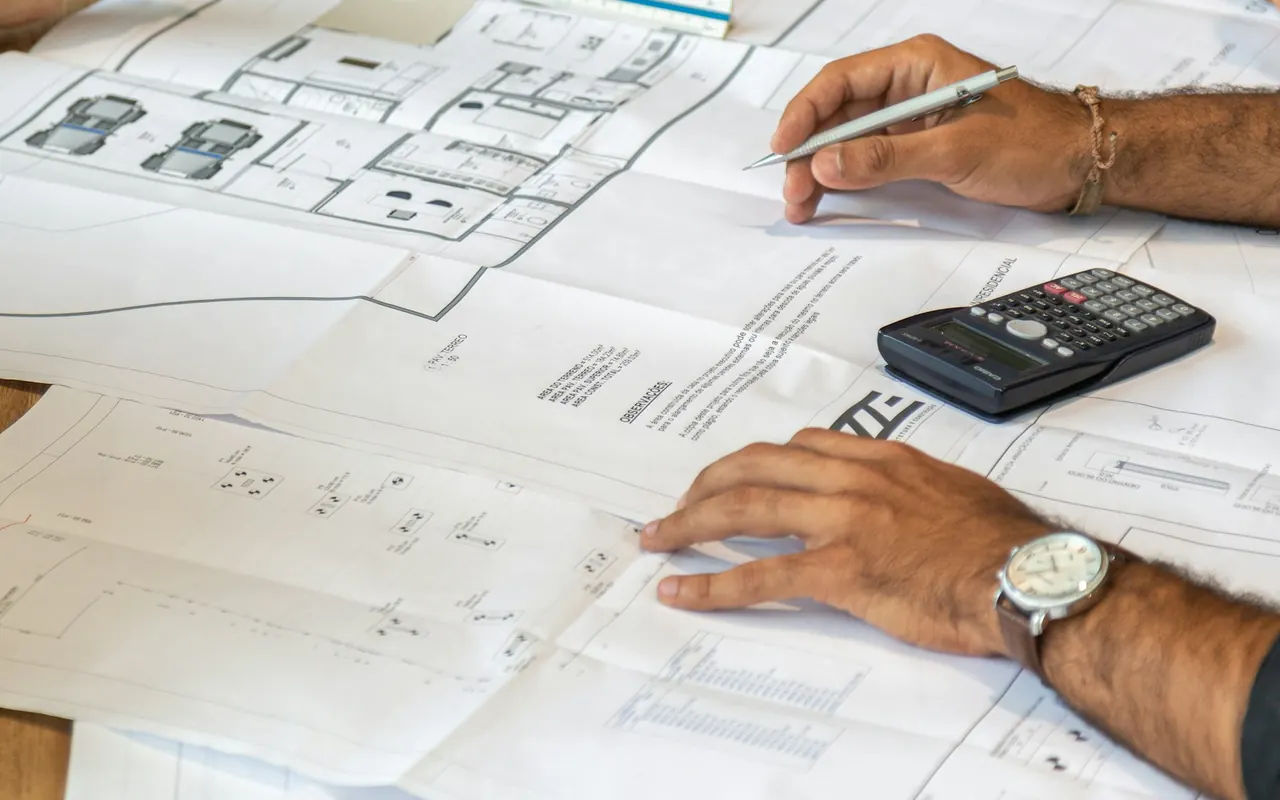 People review architectural plans at a desk