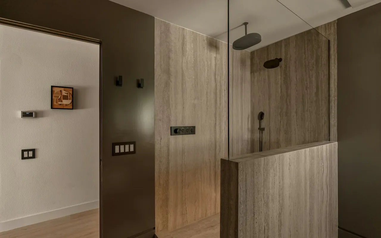 Bathroom with a glass shower enclosure, warm wood and stone finishes