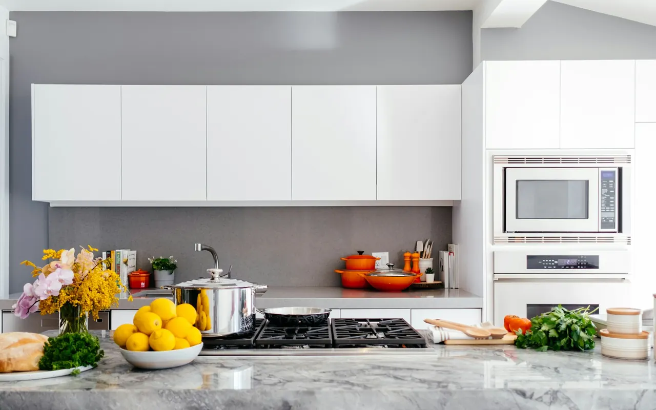 Modern white kitchen with a marble island and integrated cabinetry