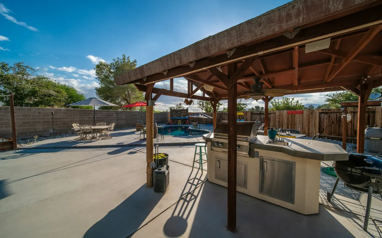 Covered outdoor patio with a grill and dining table