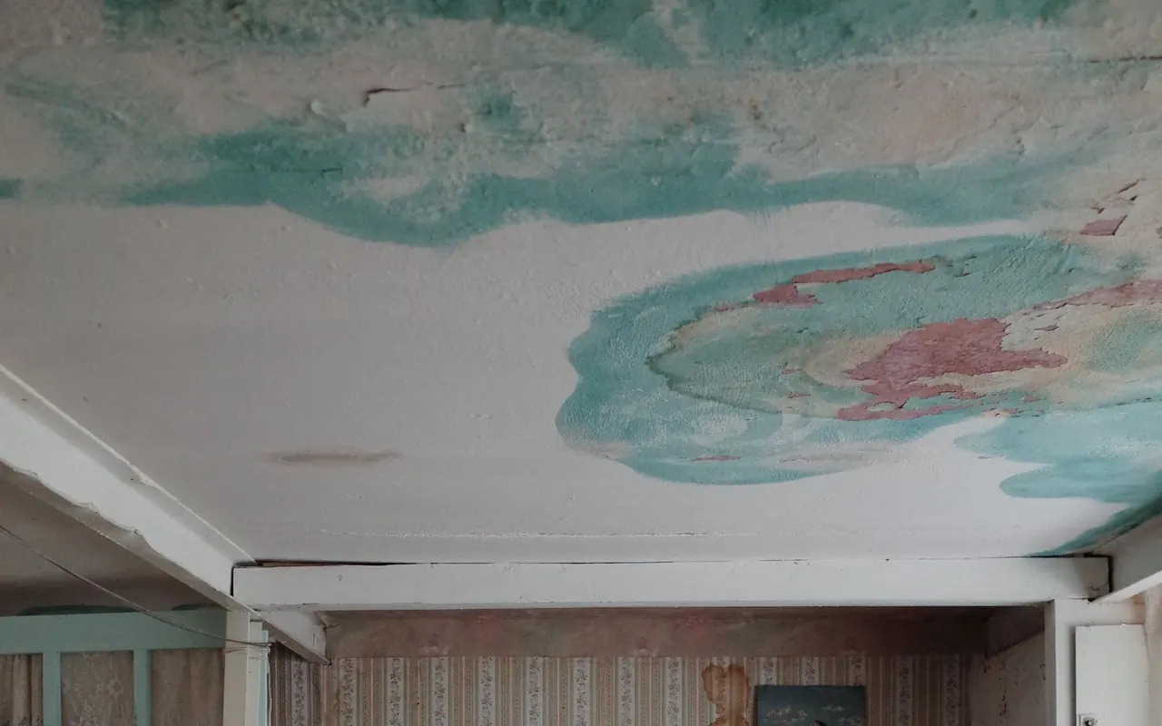 Discolored and peeling ceiling finish in a bedroom
